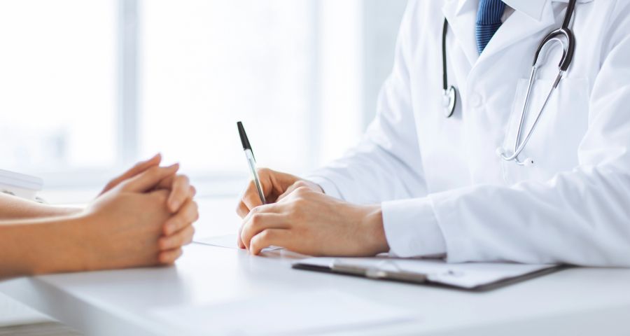 Arzt, Patientin beim Arzt, Arztgespräch am Schreibtisch