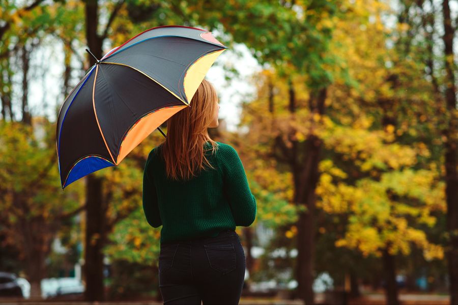 Frau mit Regenschirm im Herbst