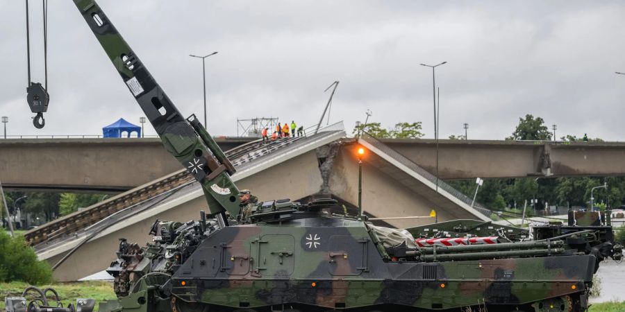 Ein Bergepanzer der Bundeswehr steht vor der eingestürzten Carolabrücke.