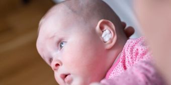 Baby mit Medikament im Ohr