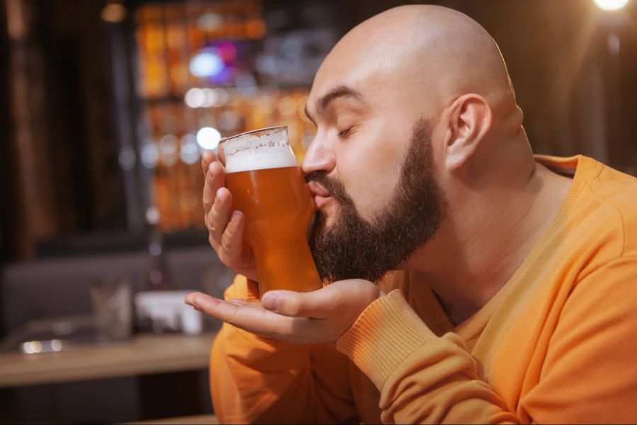 Mann küsst gefülltes Bierglas