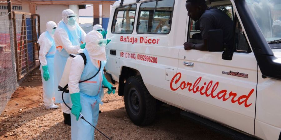 ARCHIV - Medizinisches Personal desinfiziert einen Krankenwagen im Ebola-Behandlungszentrum in Bunia. Foto: Dirole Lotsima Dieudonne/AP/dpa