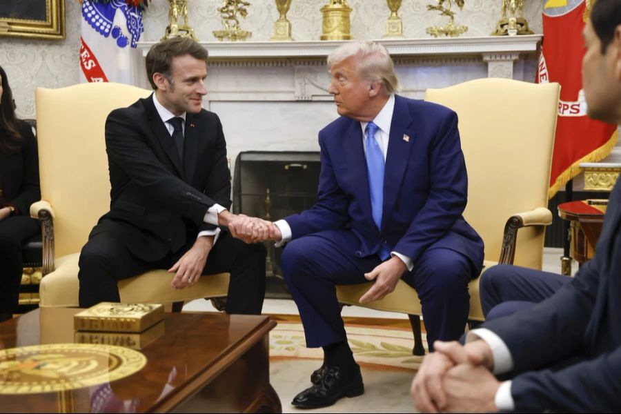 Donald Trump schüttelt die Hand von Emmanuel Macron.