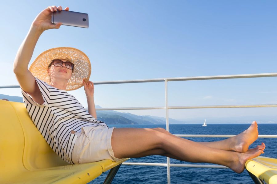 Frau auf Schiff macht Selfie