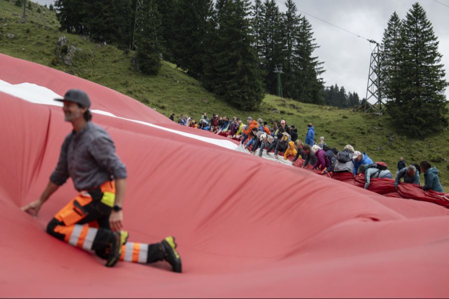 Zahlreiche Helferinnen und Helfer packten beim Entrollen auf der Alpwiese bei der Schwägalp mit an.