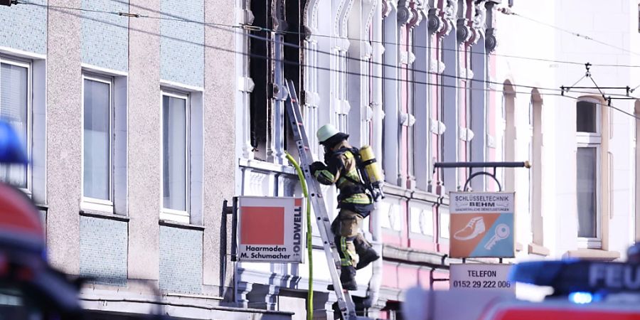 ARCHIV - Ein Feuerwehrmann klettert an einem Haus, in dem es gebrannt hat, auf einer Leiter. Der Grossbrand in einem Mehrfamilienhaus in Solingen mit vier Toten ist nach einem vorläufigen Gutachten auf vorsätzliche Brandstiftung zurückzuführen. Foto: David Young/dpa