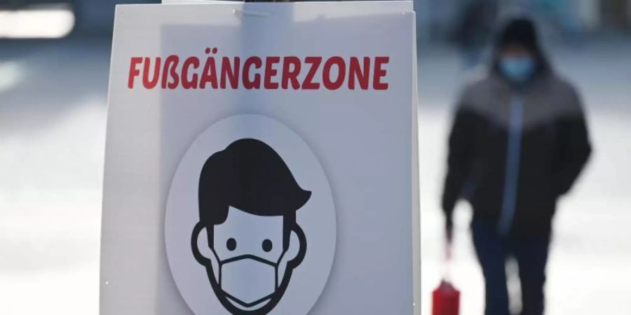 Ein Schild weist auf die Maskenpflicht in der Fussgängerzone von Göppingen hin. Foto: Marijan Murat/dpa