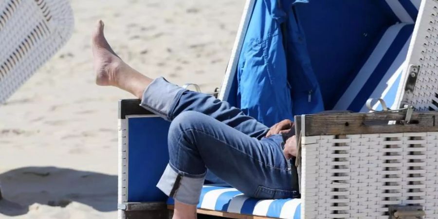 Entspannung im Strandkorb an einem Strand in Schleswig-Holstein. Foto: Bodo Marks/dpa