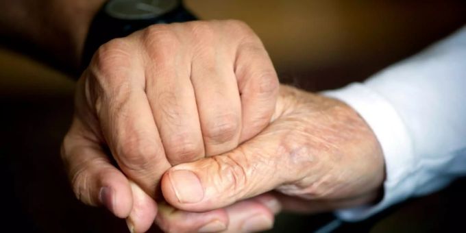 Helfer hält eine Hand in einem Pflegeheim Helfer hält eine Hand in einem Pflegeheim
