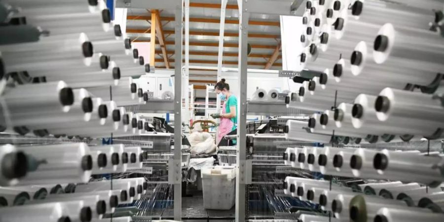 Eine Arbeiterin arbeitet in einer Fabrik für Kunststoffprodukte in der Stadt Ning'an in der nordostchinesischen Provinz Heilongjiang. Foto: Wang Jianwei/XinHua/dpa