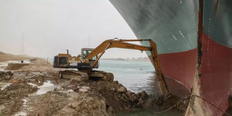 Die Arbeit eines kleinen Baggers am Bug des riesigen Schiffs wurde im Netz umgehend als Vergleich genutzt - etwa mit den Corona-Massnahmen. Foto: -/Suez Canal Authority/dpa