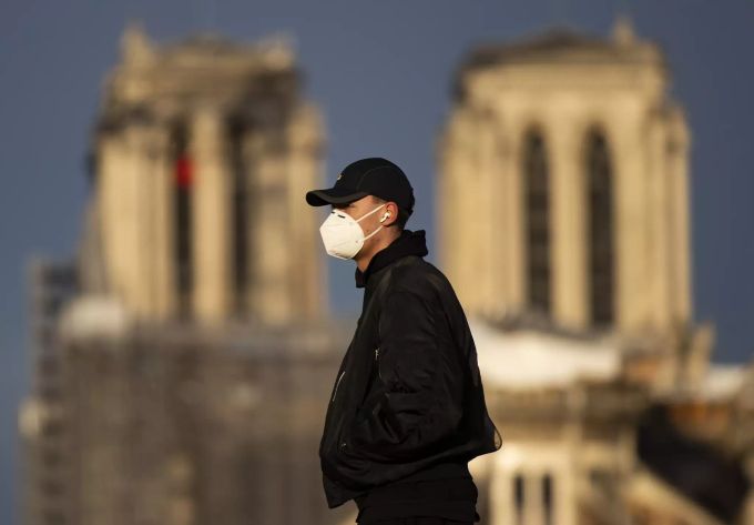 Ein junger Mann mit Schutzmaske in der Nähe der Notre-Dame Kathedrale in Paris Ende Januar 2021. Paris Covid-19