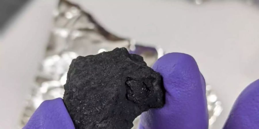 Das vom Natural History Museum veröffentlichte Foto zeigt das Fragment eines Meteoriten, der wahrscheinlich als Winchcombe-Meteorit bekannt ist und zu einem extrem seltenen Typ gehört. Foto: Kuratorium für Naturgeschichte/Natural History Museum/PA Media/dpa