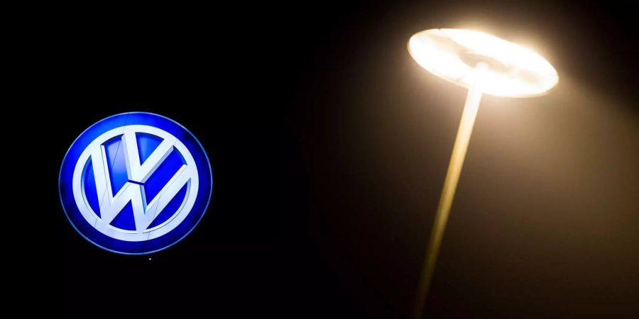 Das Volkswagen-Logo leuchtet an einem Werksgebäude in Wolfsburg (D).