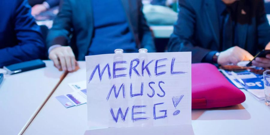 Ein Schild «Merkel muss weg!» steht beim Bundesparteitag der Alternative für Deutschland auf einem Tisch.