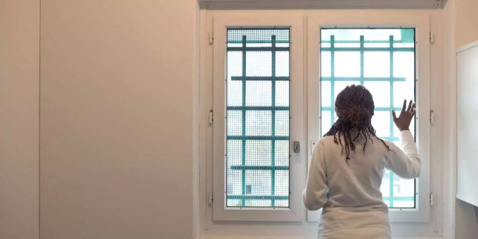 Eine Frau hinter den Gittern des Flughafengefängnis in Kloten ZH. (Archiv) Kloten
