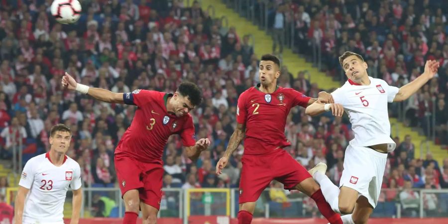 Polens Krzysztof Piatek, Portugals Pepe und Joao Cancelo sowie Polen-Spieler Jan Bednarek kämpfen im Länderspiel der UEFA Nations League um den Ball.