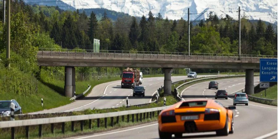 Autos fahren auf der Autobahn A1 unter einer Eisenbahnbrücke durch.