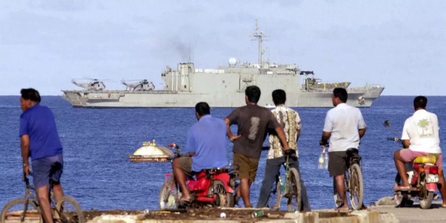 Einwohner schauen der HMAS Manoora zu, wie sie auf die Insel Nauru zusteuert.