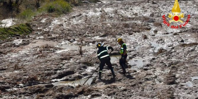 Zwei Feuerwehrmänner suchen in Italien nach einer vermissten Person.