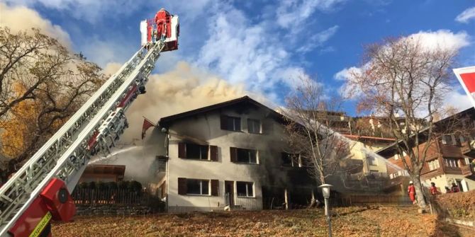 Die Feuerwehr versucht den Brand in dem Haus in Sent GR zu löschen.