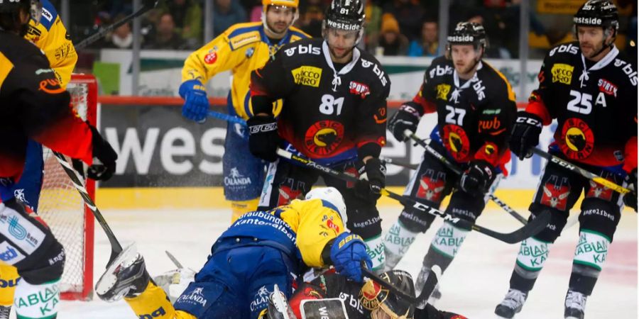 Andres Ambühl vom HC Davos liegt auf Berns Torhüter Leonardo Genoni.