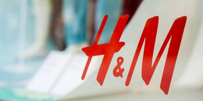 Das Logo der Bekleidungskette Hennes und Mauritz (H&M) klebt am Schaufenster einer Filiale.