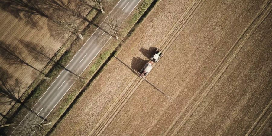 Ein Traktor fährt im März 2017 bei Göttingen über ein Feld und bringt Glyphosat aus.