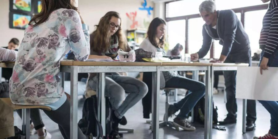 Ein Lehrer im Gespräch mit seinen Schülern und Schülerinnnen - Keystone