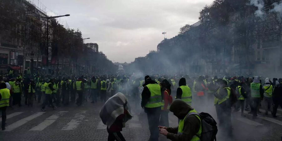 Eine Tränengaspatrone fliegt durch die Luft auf Demonstranten der «Gilets Jaunes» (Gelbwesten) zu.