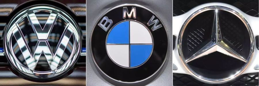 Ein VW-Logo (l-r) ein BMW-Logo und ein Mercedesstern.