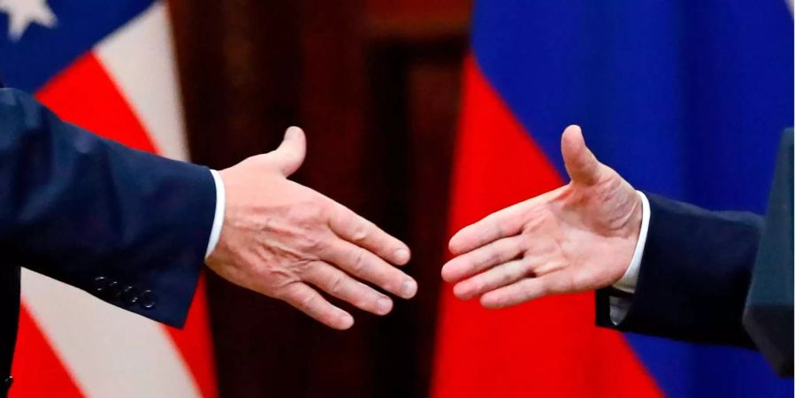 US-Präsident Donald Trump (links) und der russische Präsident Wladimir Putin (rechts) geben sich nach einem gemeinsamen Gespräch während des Gipfeltreffens in Helsinki die Hand.