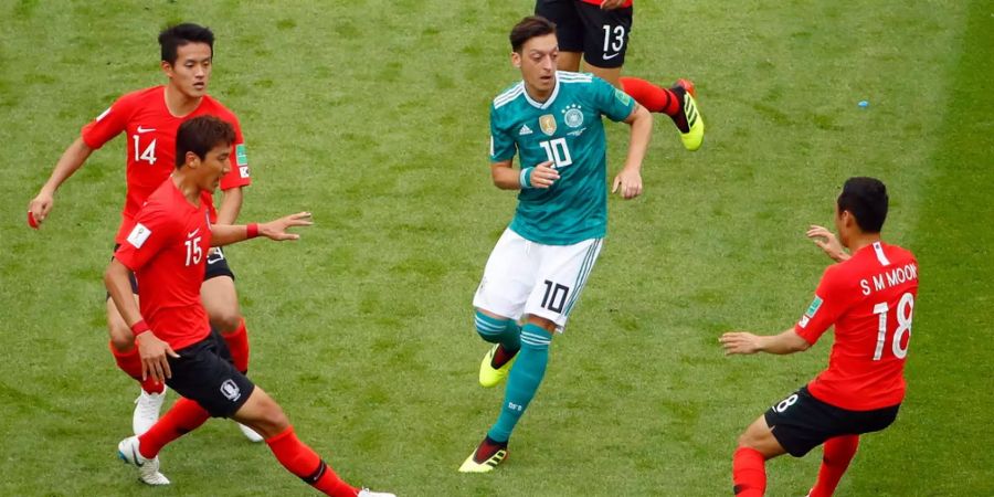 Sensationell ausgeschieden: Mesut Özil umzingelt von Hong Chul, Woo Jung und S.M. Moon