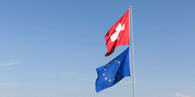Die EU könnte die Schweiz auf eine neue schwarze Liste setzen (Symbolbild). Eine Schweizer Fahne und die Fahne der EU in Zürich.