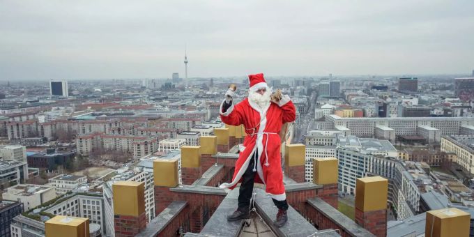 Ein Weihnachtsmann in Berlin auf einem Dach. Weihnachtsmann in Berlin