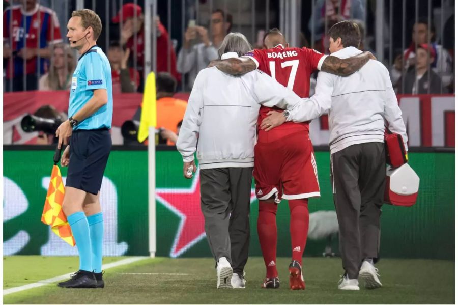 Boateng verlässt gestützt auf einen Physio und Bayern-Doc Müller-Wohlfahrt (links) humpelnd das Feld.