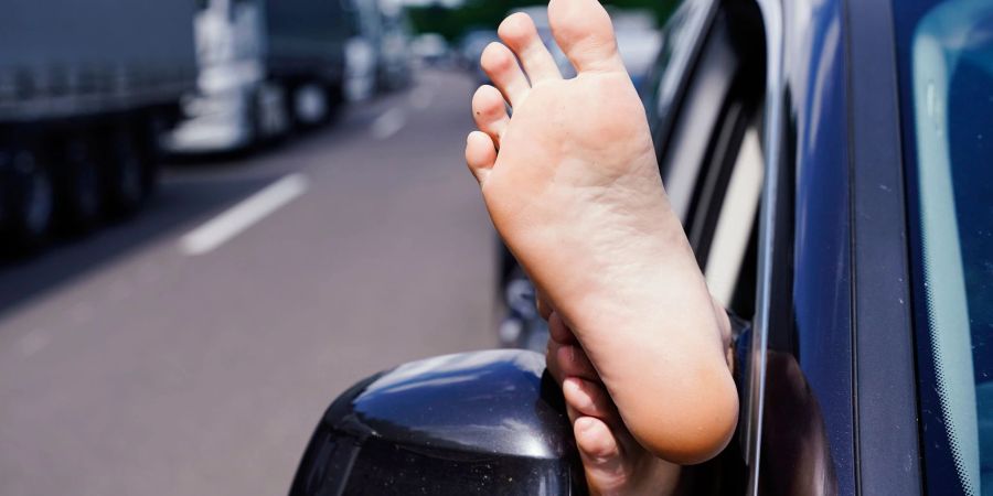 Gut gelüftet: Füsse hochlegen beim Autofahren mag für Beifahrer bequem und erfrischend sein, kann aber sehr schnell extrem gefährlich werden.