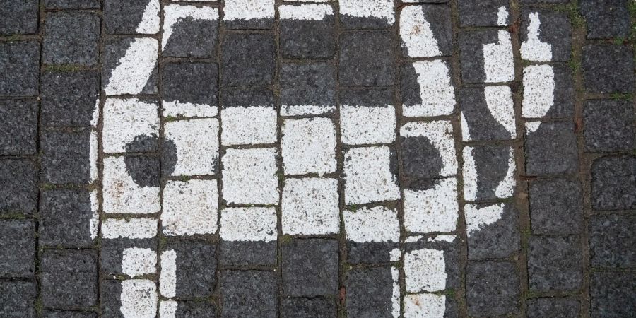 Ein Symbol markiert einen Parkplatz mit einer öffentlichen Ladesäule für Elektroautos in der Innenstadt von Hannover.