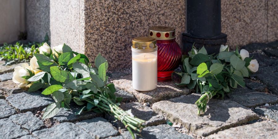 An der Strassenecke zur Zufahrt zum Kinder- und Jugendhilfezentrum, in dem eine Zehnjährige tot aufgefunden wurde, liegen weisse Rosen und Grablichter auf dem Gehweg.