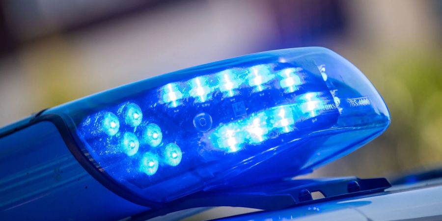 Ein Blaulicht ist auf dem Dach eines Polizeifahrzeugs zu sehen.
