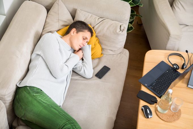 Pausen sollten bei Fatigue ein fester Bestandteil der Tagesplanung sein. Frau Sofa schlafen Laptop grau
