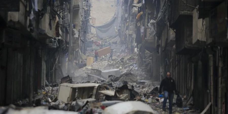 In einem östlichen Stadtteil von Aleppo fliehen Menschen vor dem Krieg (Archivbild). Foto: Hassan Ammar/AP/dpa