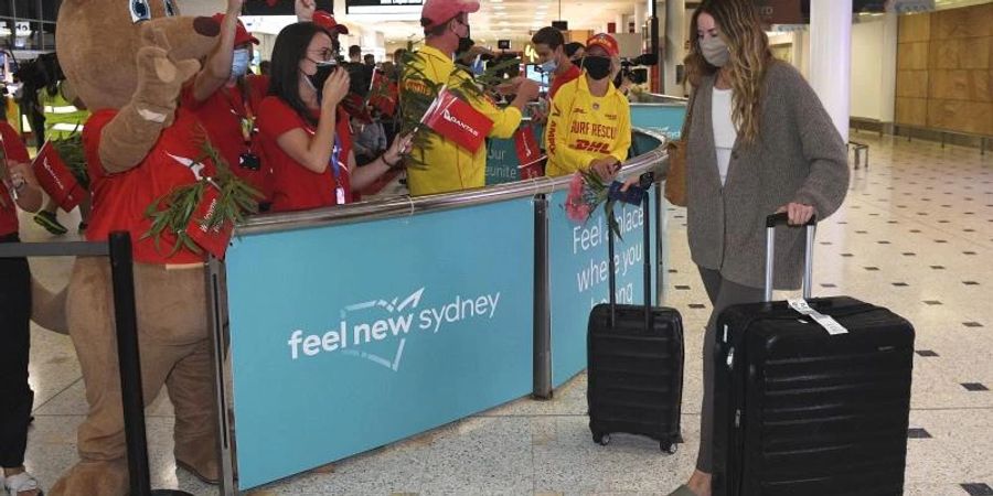 Passagiere werden bei ihrer Ankunft am Sydney International Airport in Sydney begrüsst. Internationale Touristen und Geschäftsreisende kamen zum ersten Mal seit fast zwei Jahren ohne grössere Einschränkungen in Australien an. Foto: Dean Lewins/AAP via AP/dpa