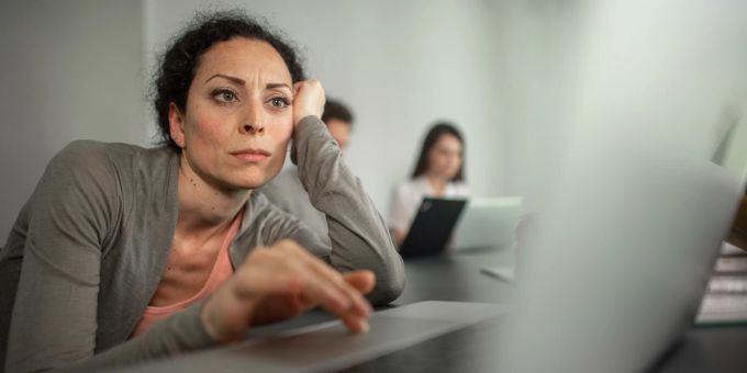 Wer sehr häufig frustriert zur Arbeit geht, sollte das Gespräch mit Vorgesetzten suchen. Frau frustriert Laptop grau