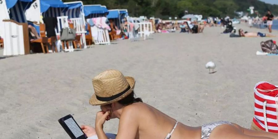 Badegäste liegen bei sonnigem Wetter am Ostsee-Strand. Ein Hochdruckgebiet sorgt in Deutschland für heisses Spätsommer-Wetter. Foto: Bodo Marks/dpa