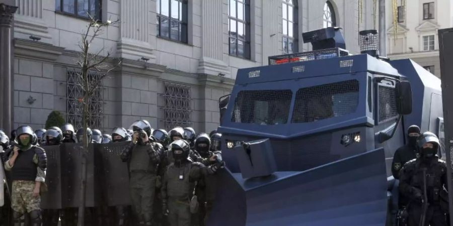 Bereitschaftspolizisten blockieren eine Strasse mit einem Militärfahrzeug in Minsk. Foto: ---/AP/dpa