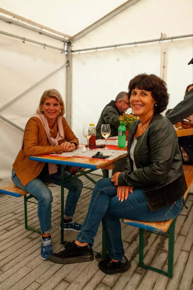 Trudy und Sandra stossen mit einem Glas Weisswein zusammen auf das Wochenende an. Street Food Tavolata Kloten