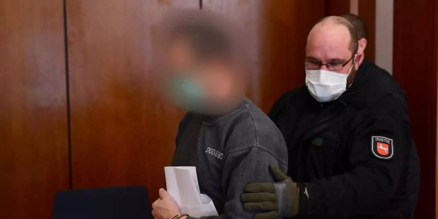 Der Angeklagte wird in den Gerichtssaal im Göttinger Landgericht geführt. Foto: Swen Pförtner/dpa