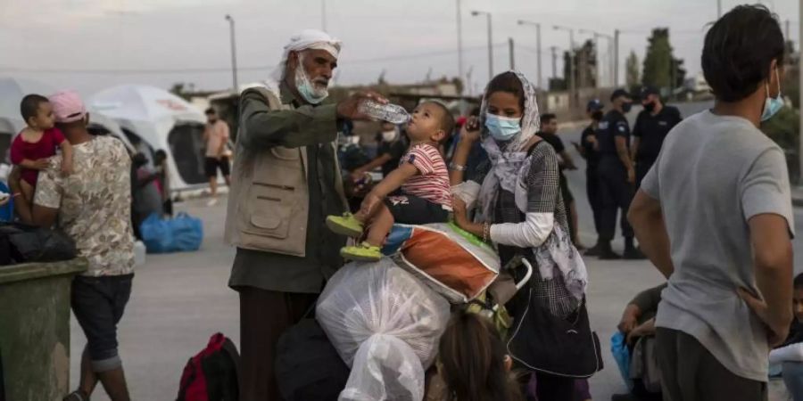 Ein Afghane gibt einem Kind Wasser. Die europäische Migrationspolitik steht heute mal wieder im Fokus. Foto: Petros Giannakouris/AP/dpa