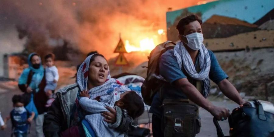 Bewohner des Flüchtlingslagers Moria fliehen vor den Flammen. Foto: Petros Giannakouris/AP/dpa